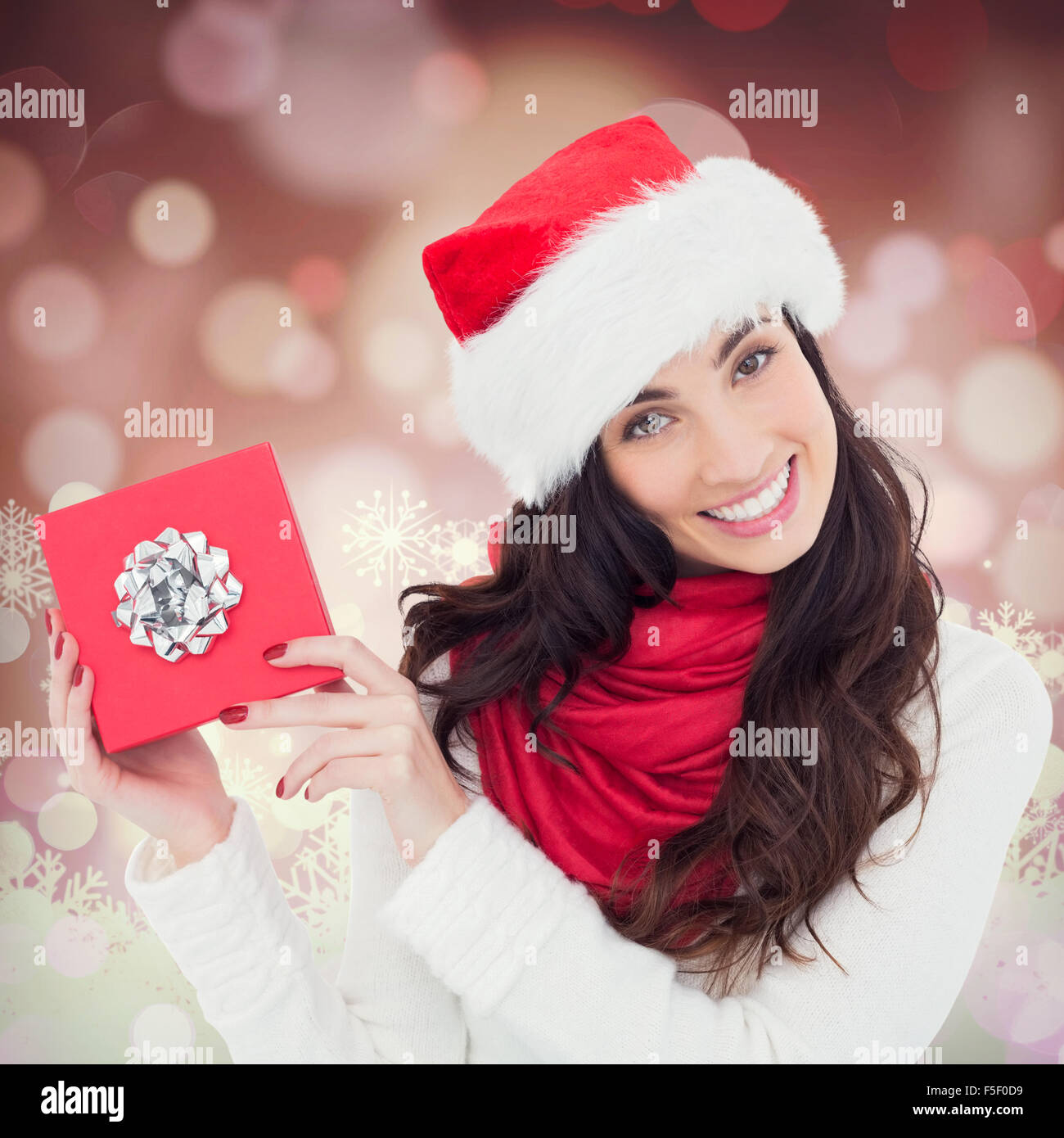 Composite image of joyful brunette presenting christmas gift Stock Photo