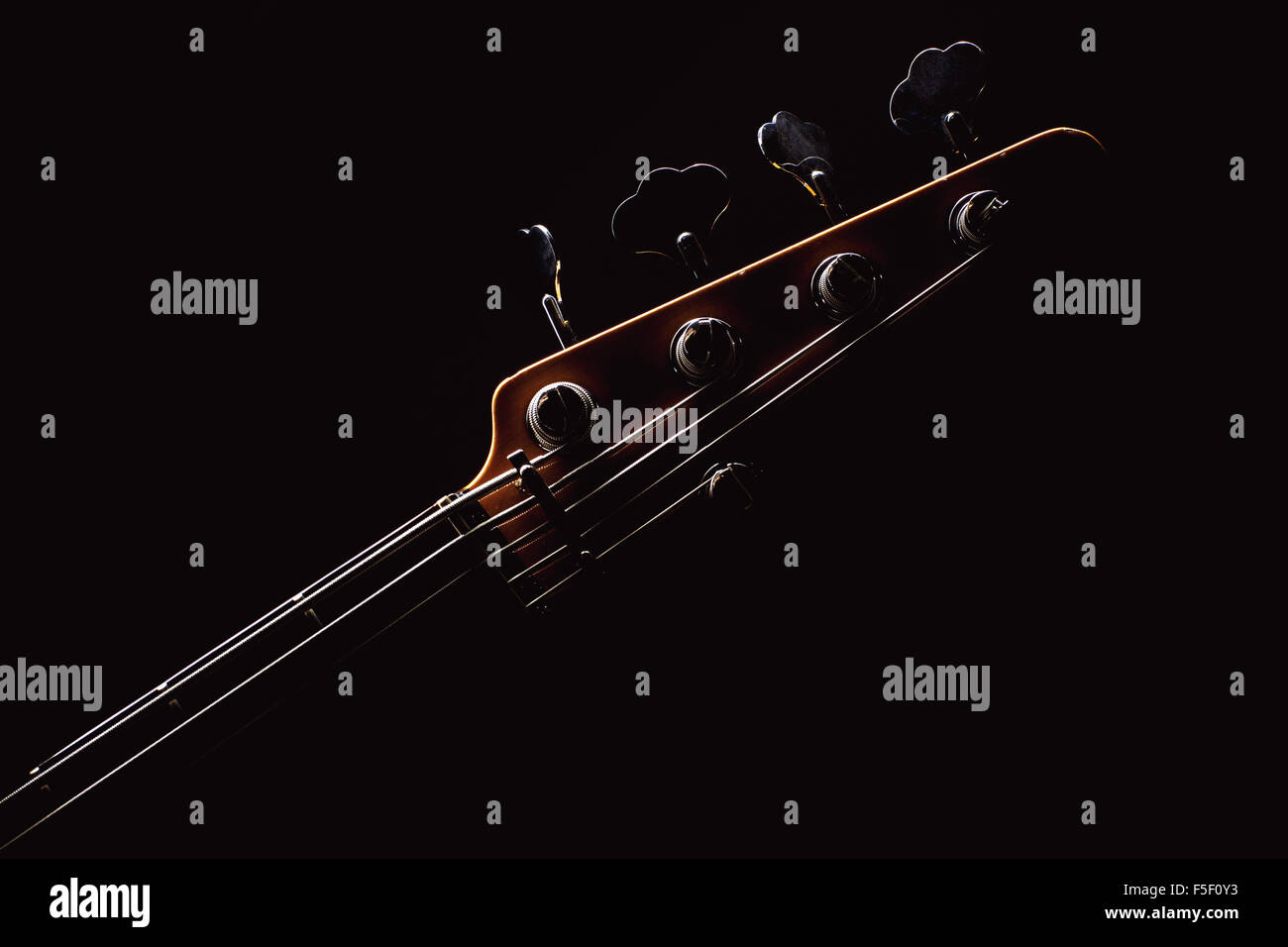 Part of a jazz bass guitar, accentuated shapes with illumination. Stock Photo