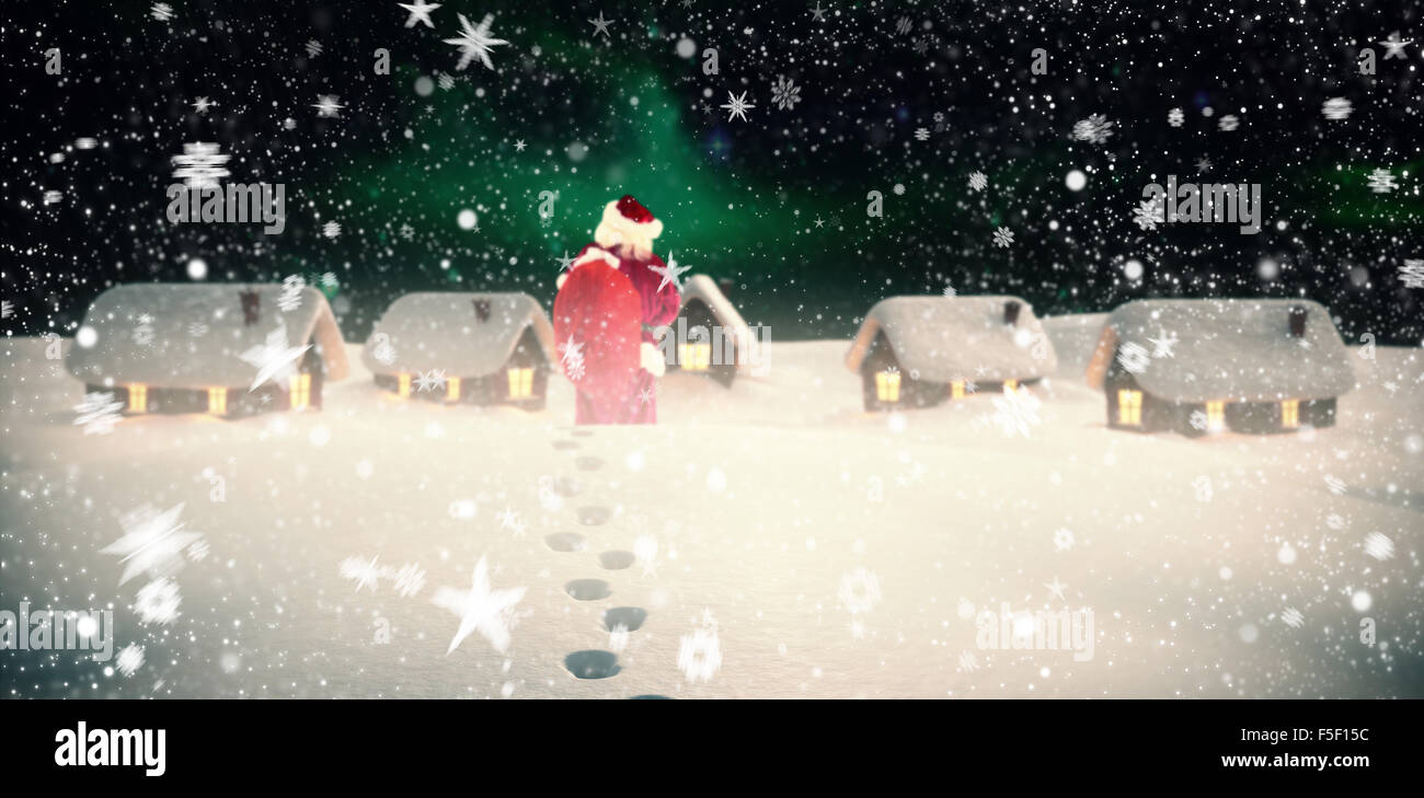 Composite image of santa is holding his bag in one hand Stock Photo - Alamy