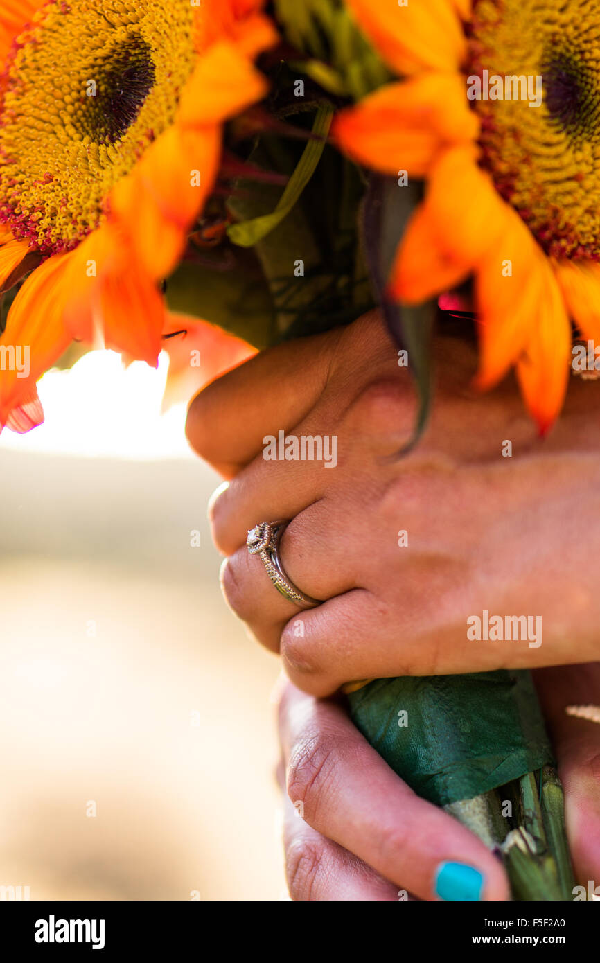 A bride holding a bouquet with focus set upon her wedding ring Stock Photo