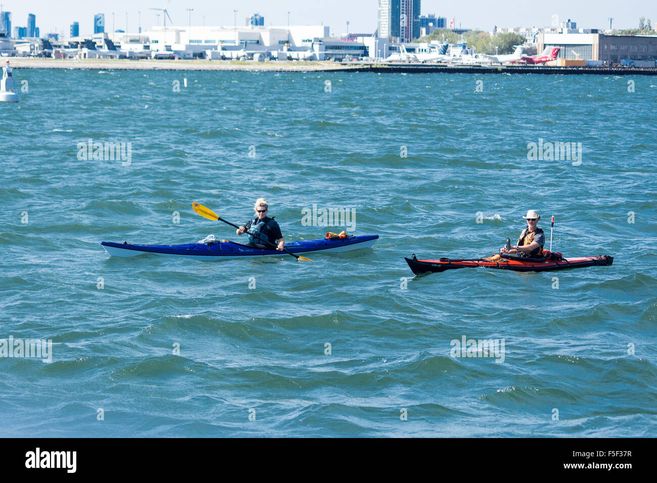 People kayaking on Lake Ontario in front of Billy Bishop Airport on the Toronto Islands in Toronto Ontario Canada Stock Photo