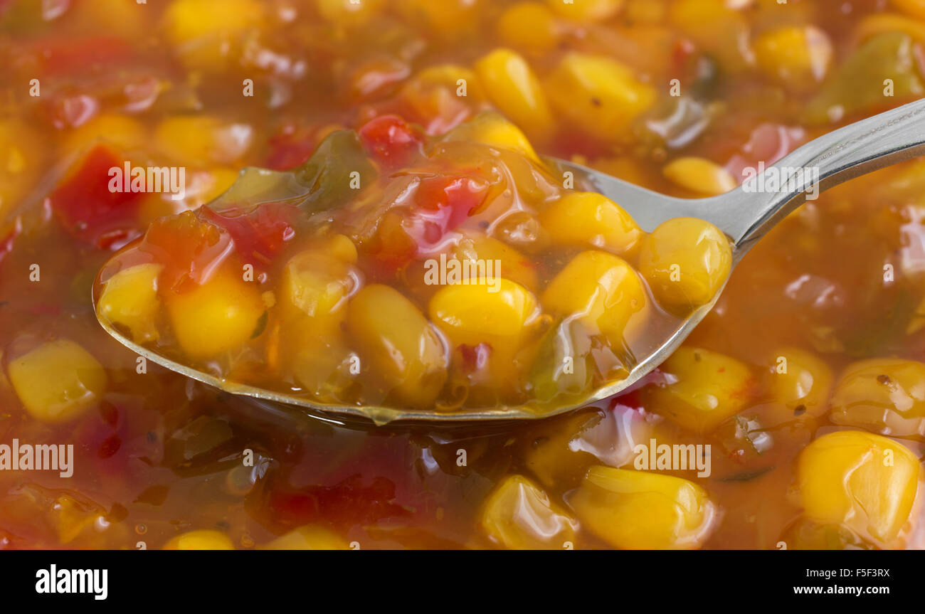 A very close view of corn relish on a spoon illuminated with natural light. Stock Photo