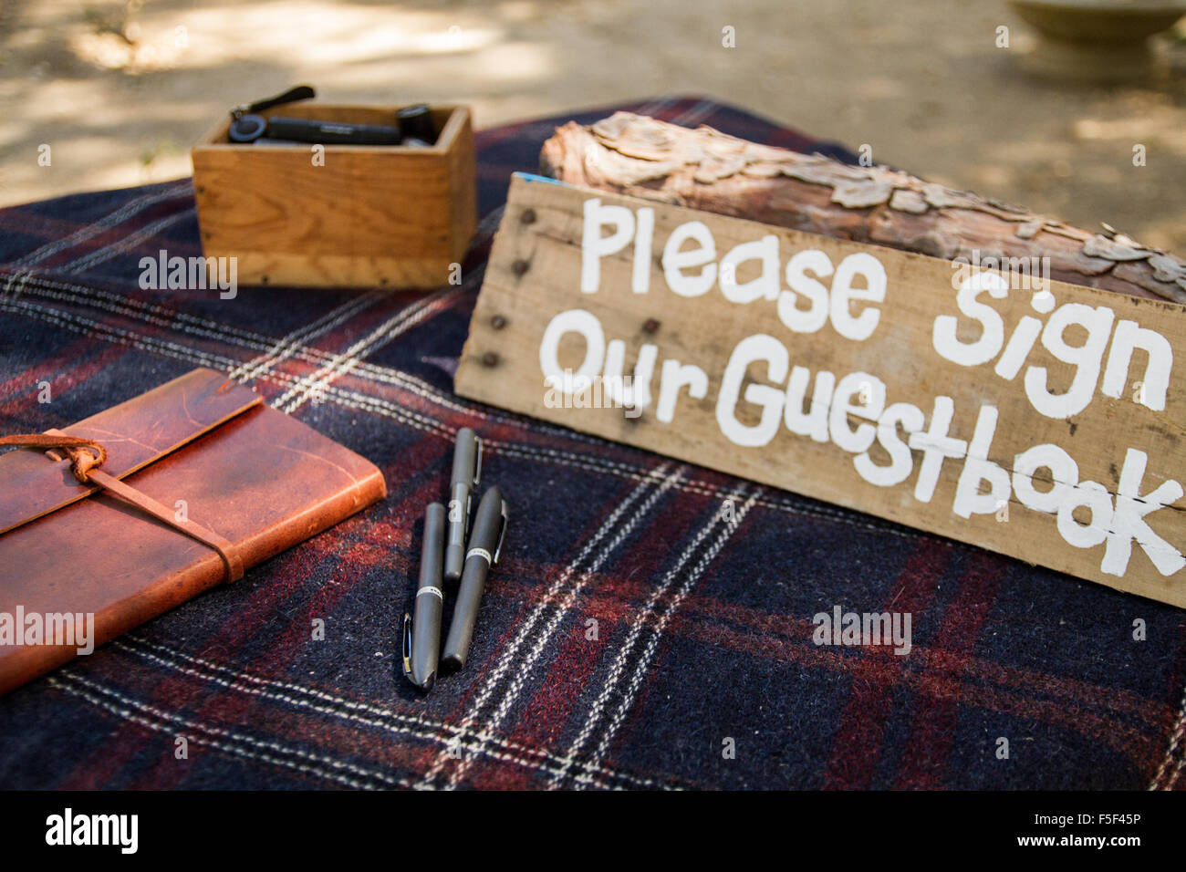 A rustic sign displaying the works 'please sign our guestbook' Stock Photo