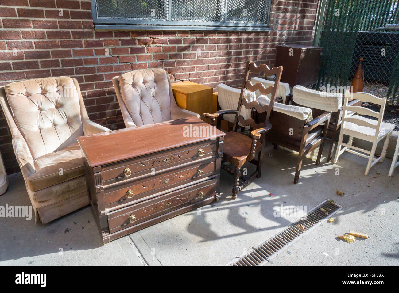 An assortment of furniture from a vacated apartment awaits bulk pick-up in the trash area of an apartment building in New York on October 31, 2015. The NYC Dept. of Health advises not to reuse furniture found in the trash because of the danger of bedbug infestations.(© Richard B. Levine) Stock Photo