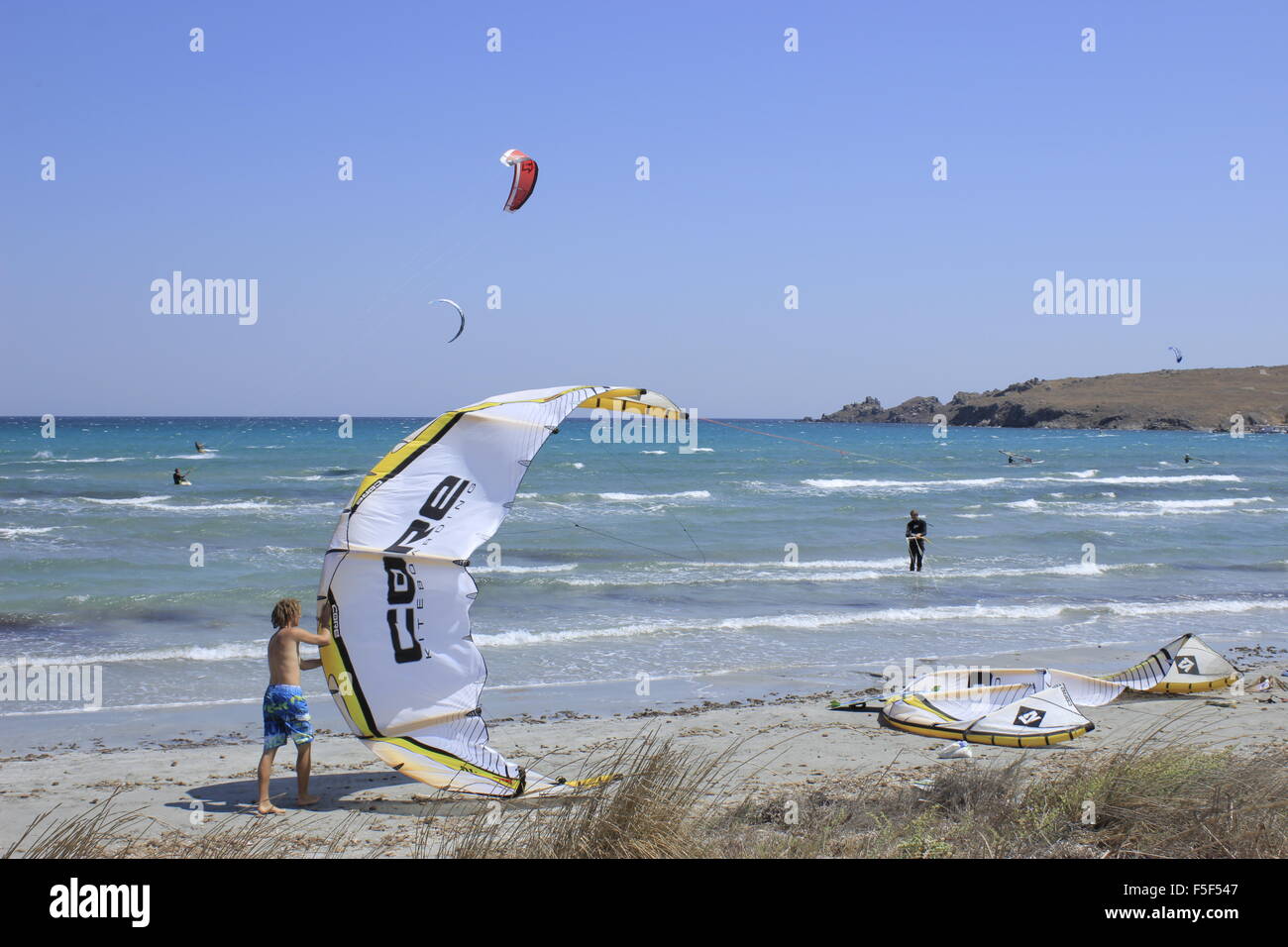 Parasurfer folding his kite struts on Keros bay beach, Lemnos or limnos island, Greece. Stock Photo