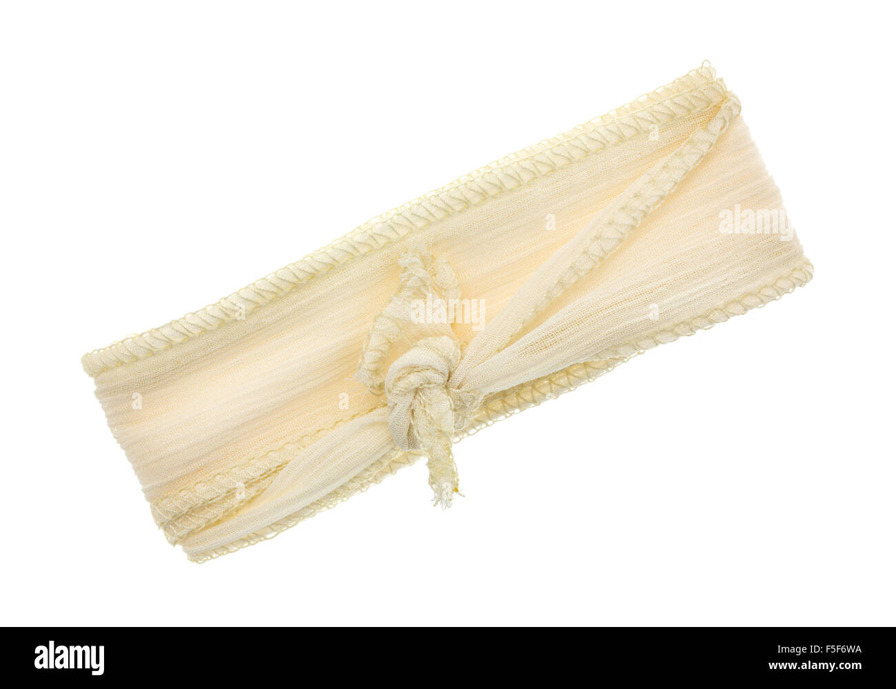 A small length of ivory ribbon cloth with a binding stitch tied isolated on a white background. Stock Photo