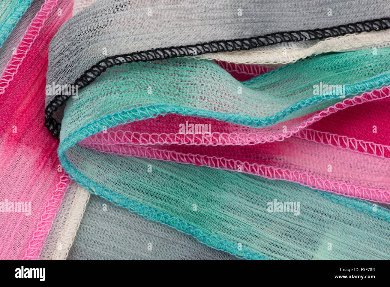 Close view of green ivory and gray polyester ribbon unfolded. Stock Photo