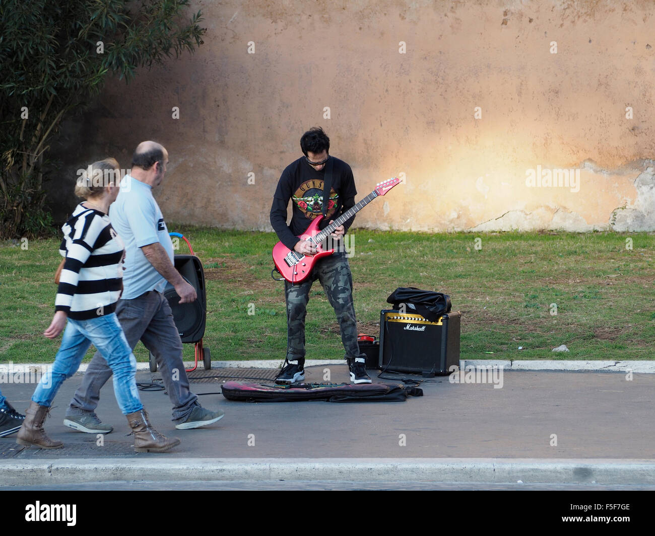 Hard rock guitarist playing on the streets of Rome, Italy, near the colosseum Stock Photo