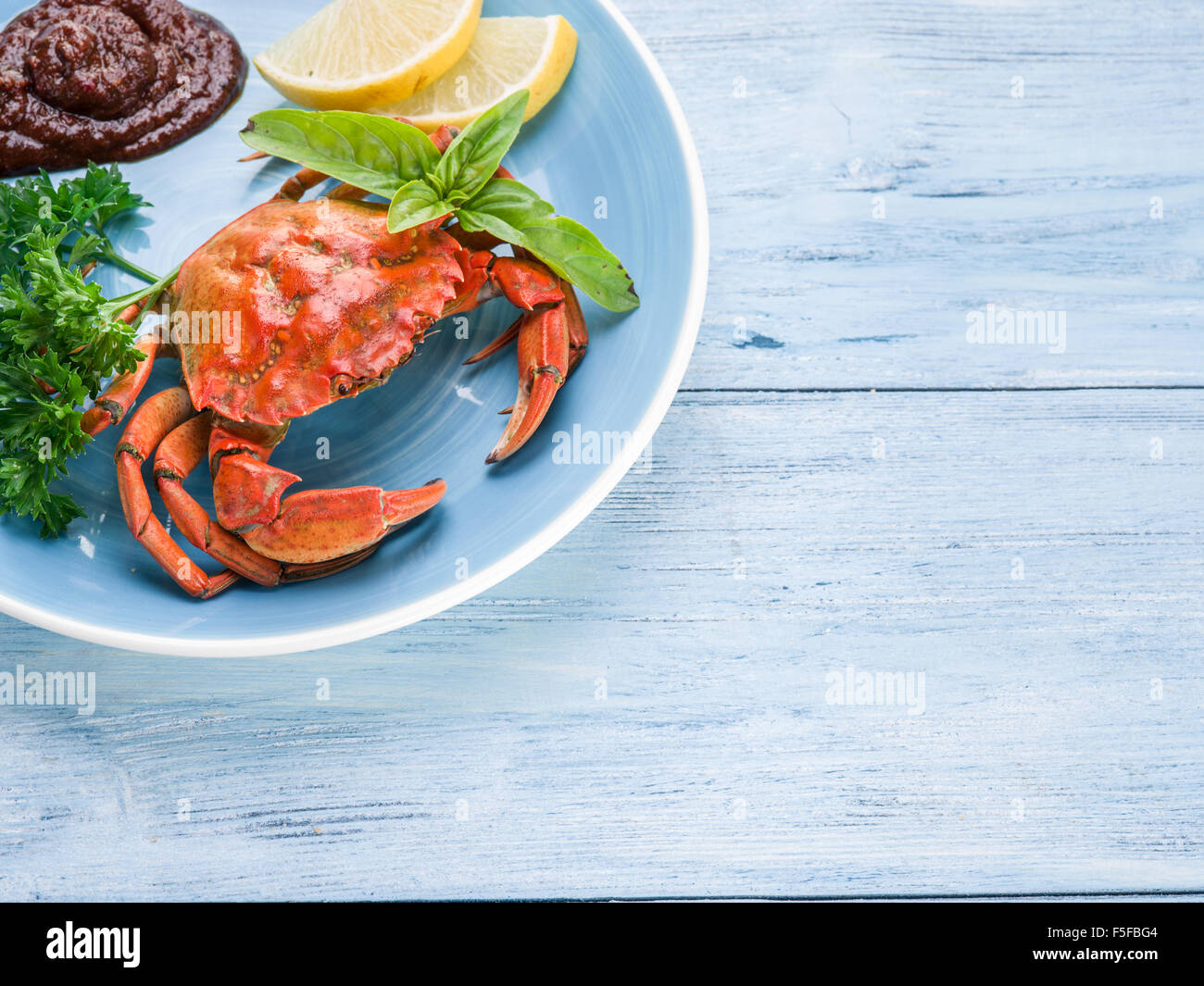 Seafood dish - cooked crab with lemon and herbs. Stock Photo