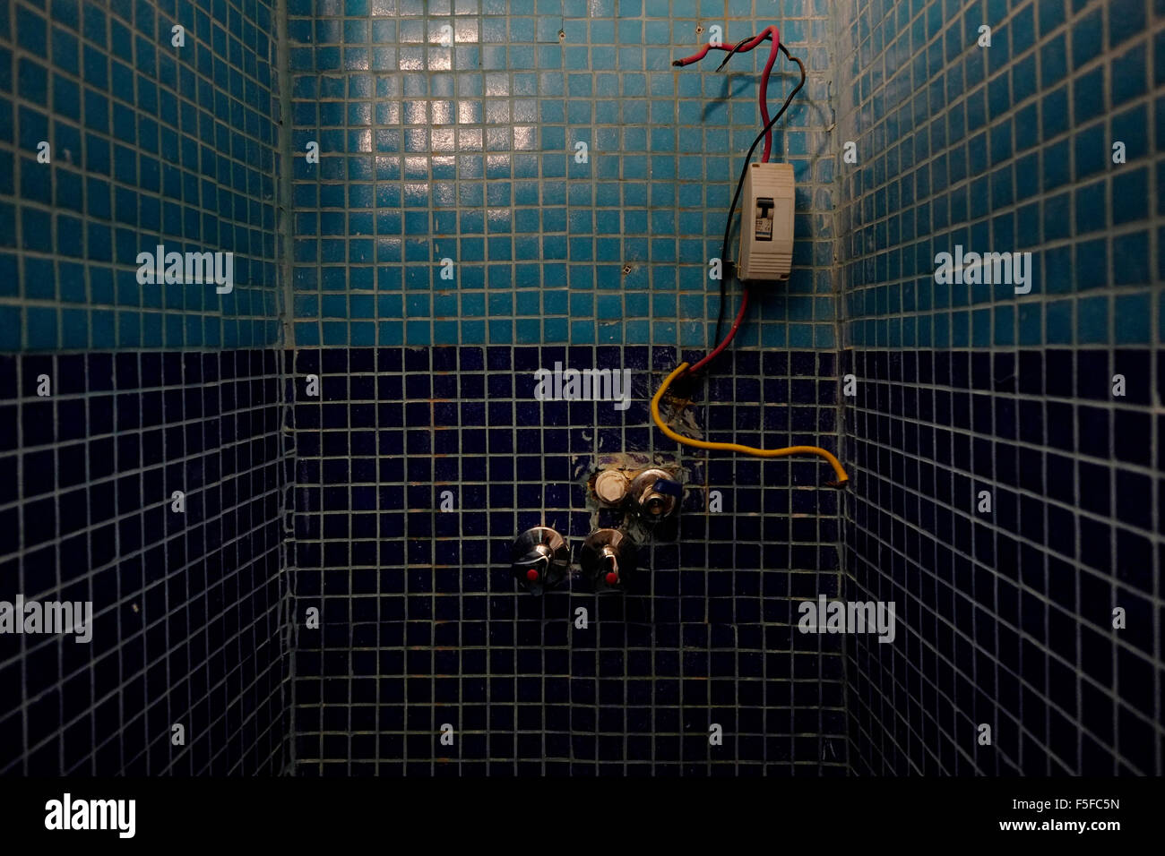 Electric junction box set into a shower wall showing connection and