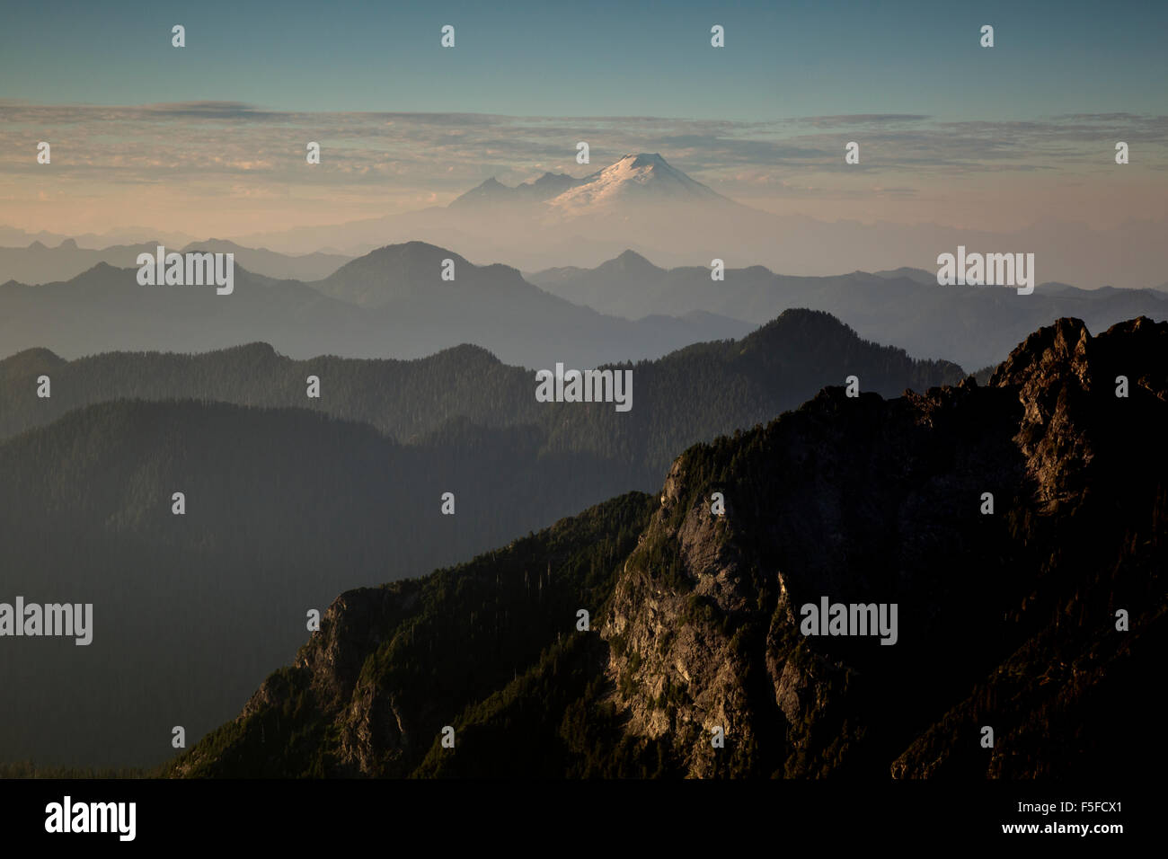 WASHINGTON - Sunset over the Cascade Mountain Range with Mount Baker standing tall over the surrounding hills and mountains. Stock Photo