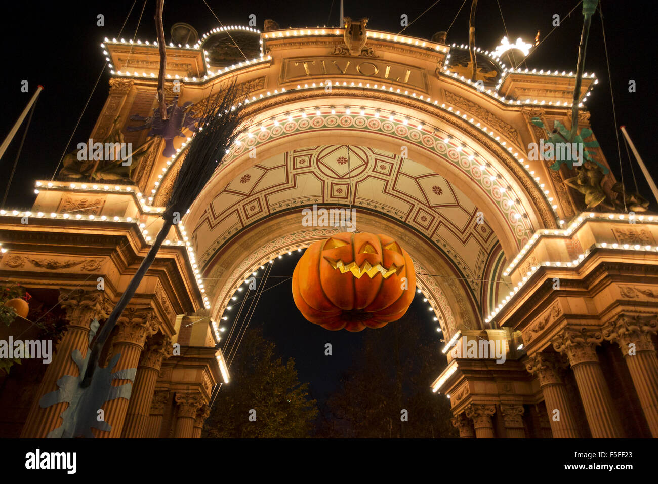 A large, spooky pumpkin head in the archway in the entrance to the Tivoli gardens in Copenhagen on a dark Halloween night Stock Photo