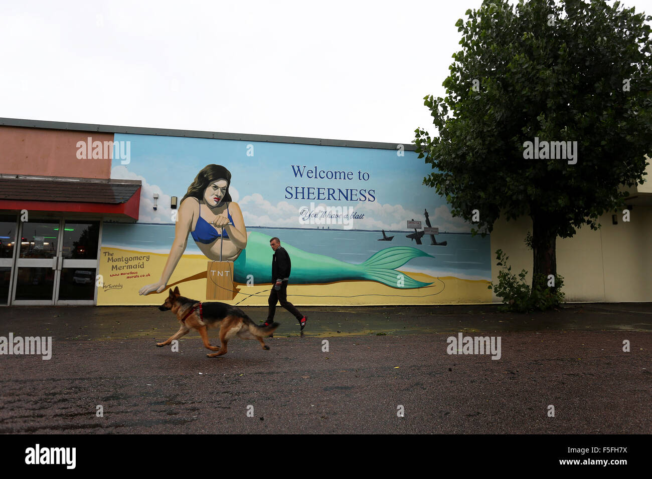 A painted wall in Sheerness, Kent, with a grumpy mermaid about to blow up the place with 'Welcome to Sheerness' in text above. Stock Photo