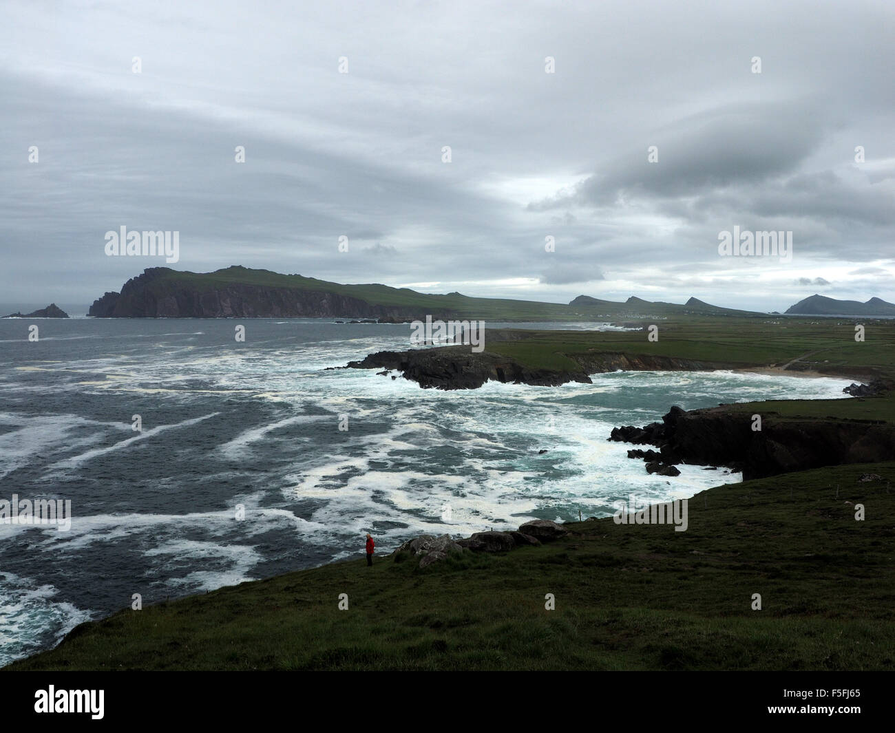 Turbulent sea waves crashing into bays and coves between Dunquin and  Ballyferriter on Dingle peninsula Ireland under dark sky Stock Photo