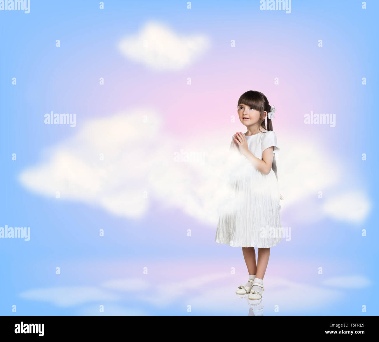 Cute little girl in blue sky with clouds Stock Photo - Alamy