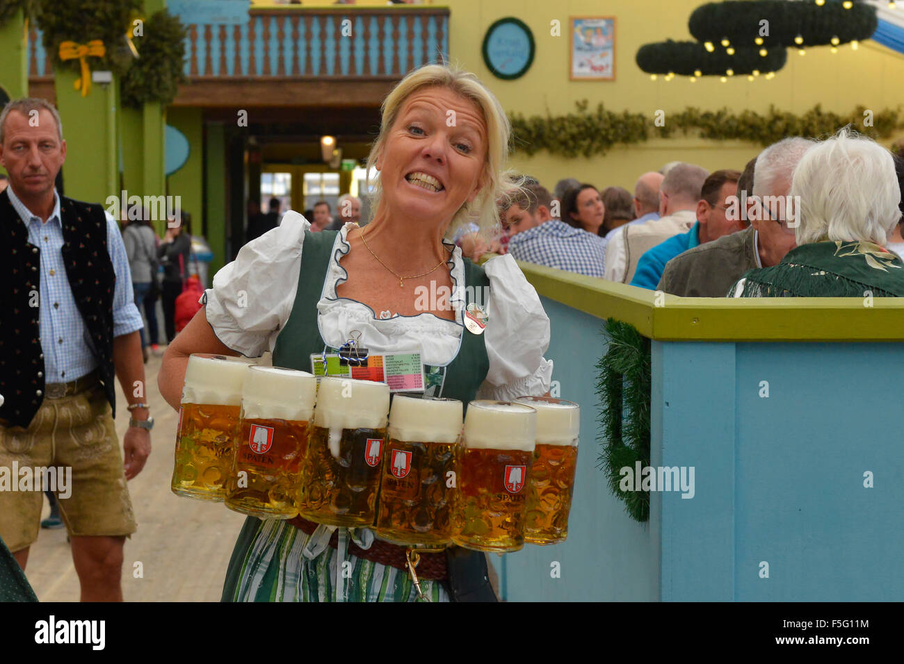Waitress carrying masses of beer at Oktoberfest in Munich, Germany Stock Photo