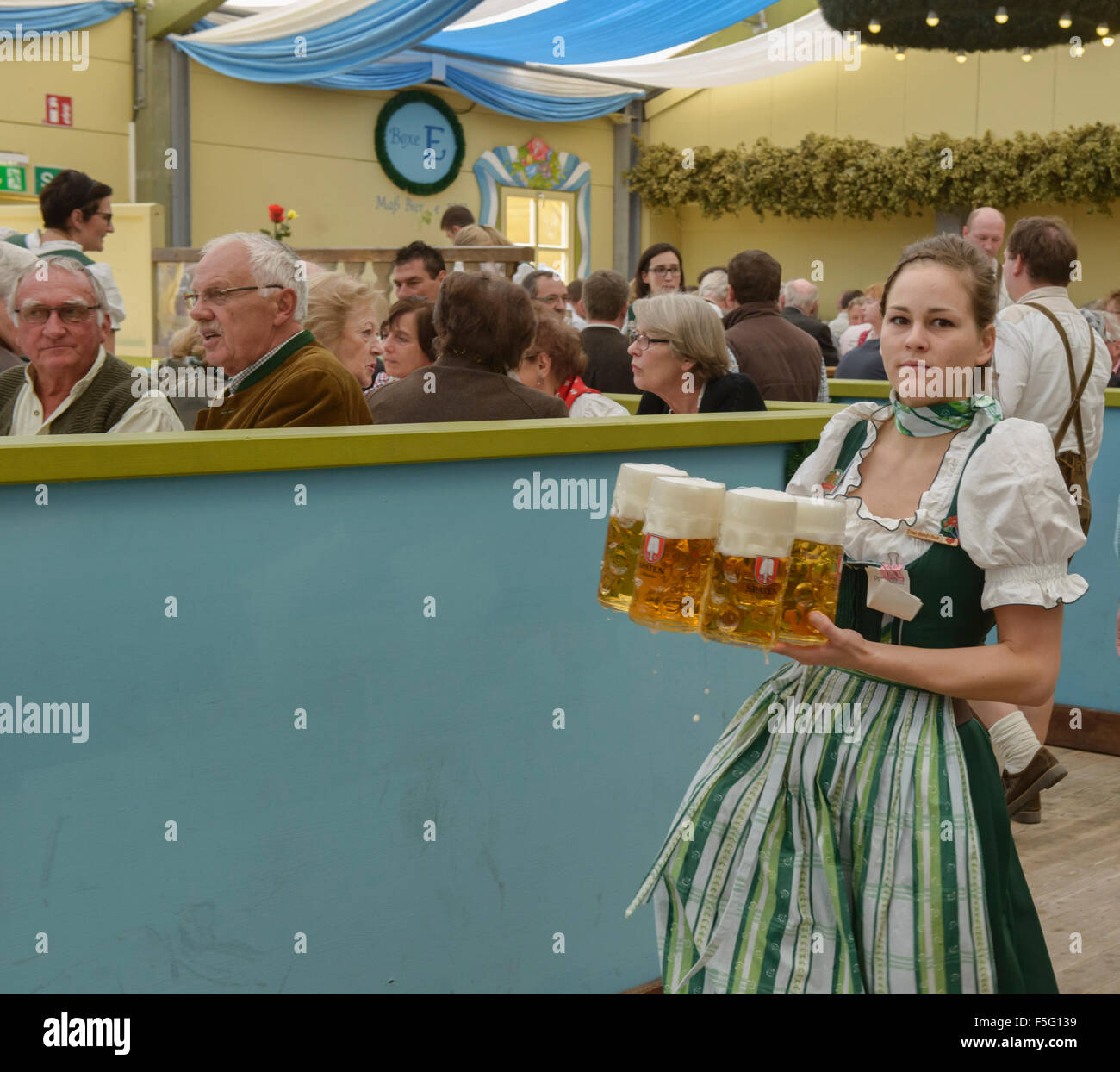 Waitress carrying masses of beer at Oktoberfest in Munich, Germany Stock Photo