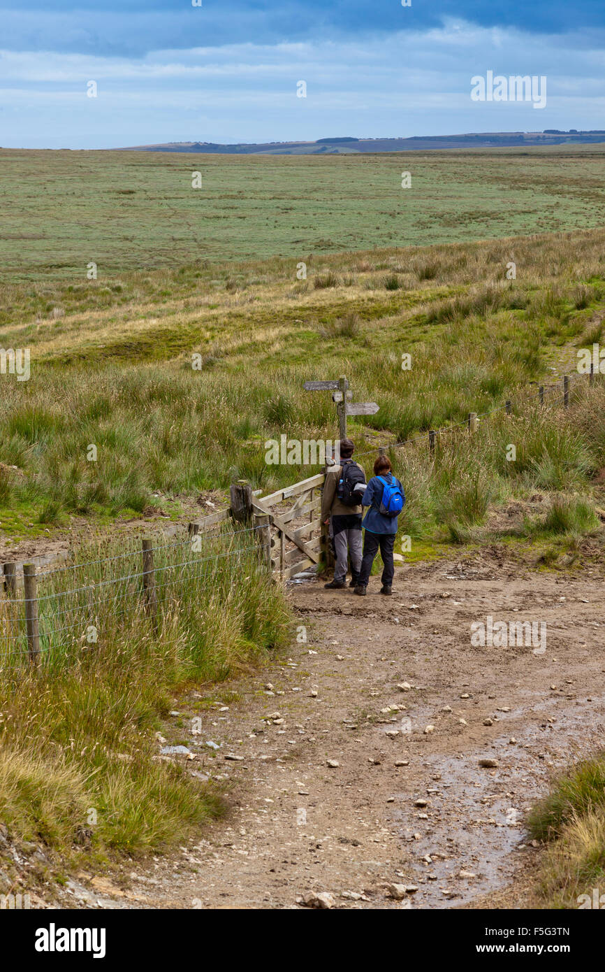 Two walkers reading the signpost at Exe Head, the source of the River