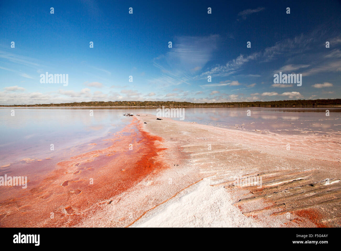 Vast outback landscape with unusual vivid pink layers of salt beside calm blue and pink waters of lake in Murray Sunset National Park Australia Stock Photo