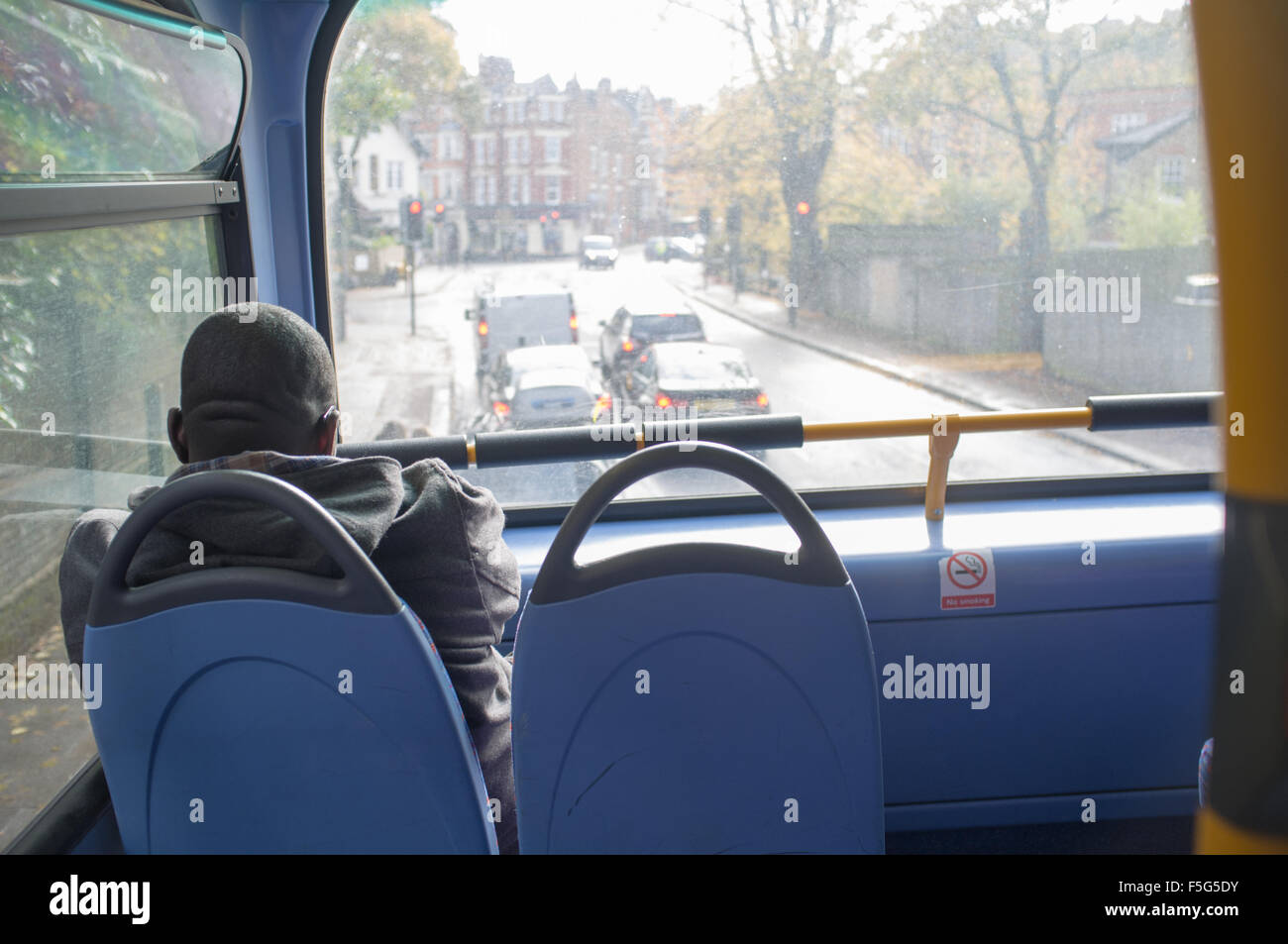 A passenger sitting on the front seat of a London bus Stock Photo