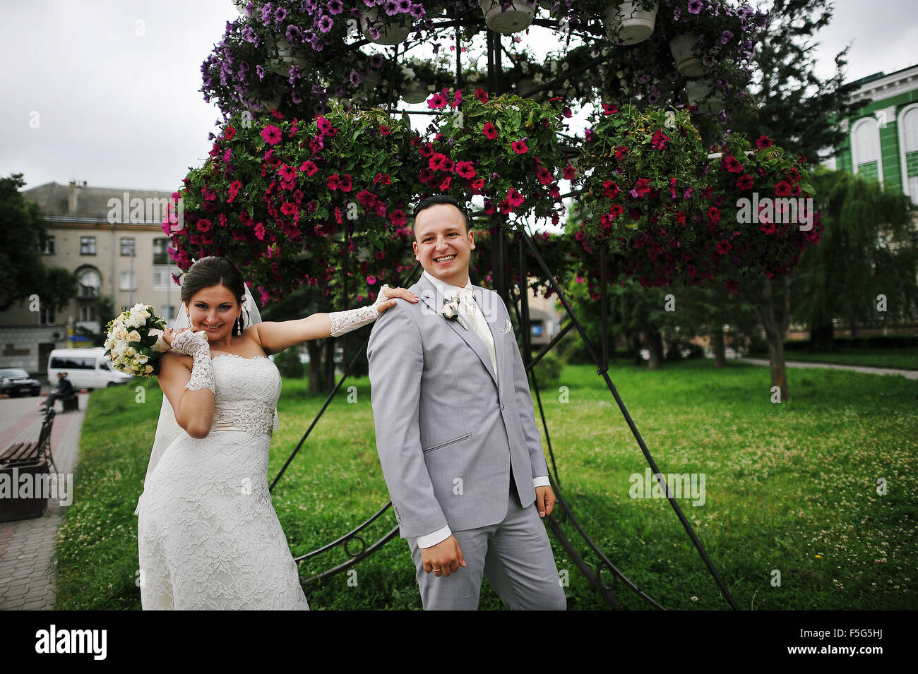 Happy wedding couple on backqround red flowers Stock Photo - Alamy