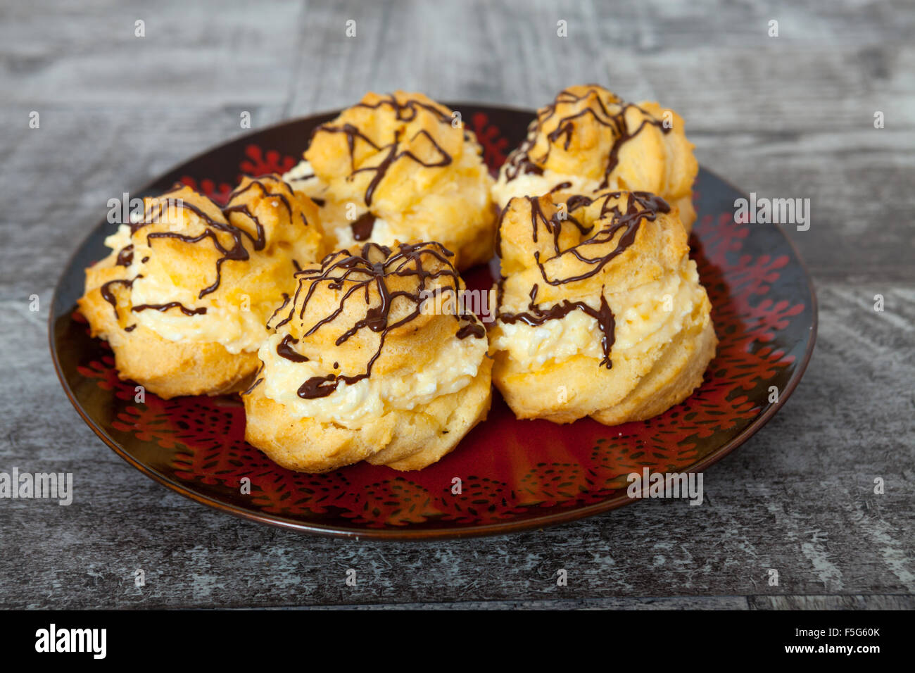 Cream puffs filled with pastry cream and sprinkled with Chocolate Stock Photo
