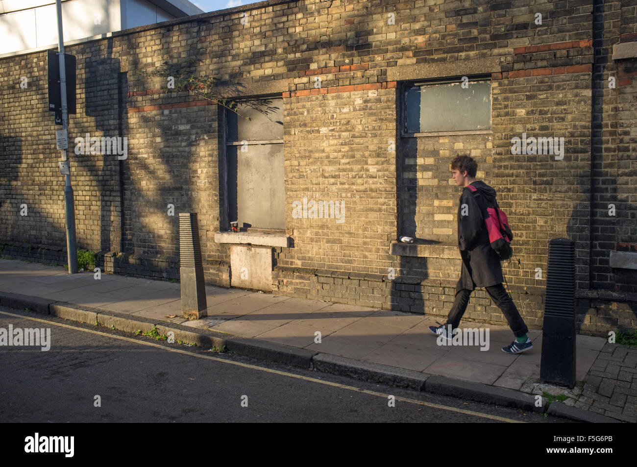 A  young man walking home on an autumn evening in Islington, North London Stock Photo