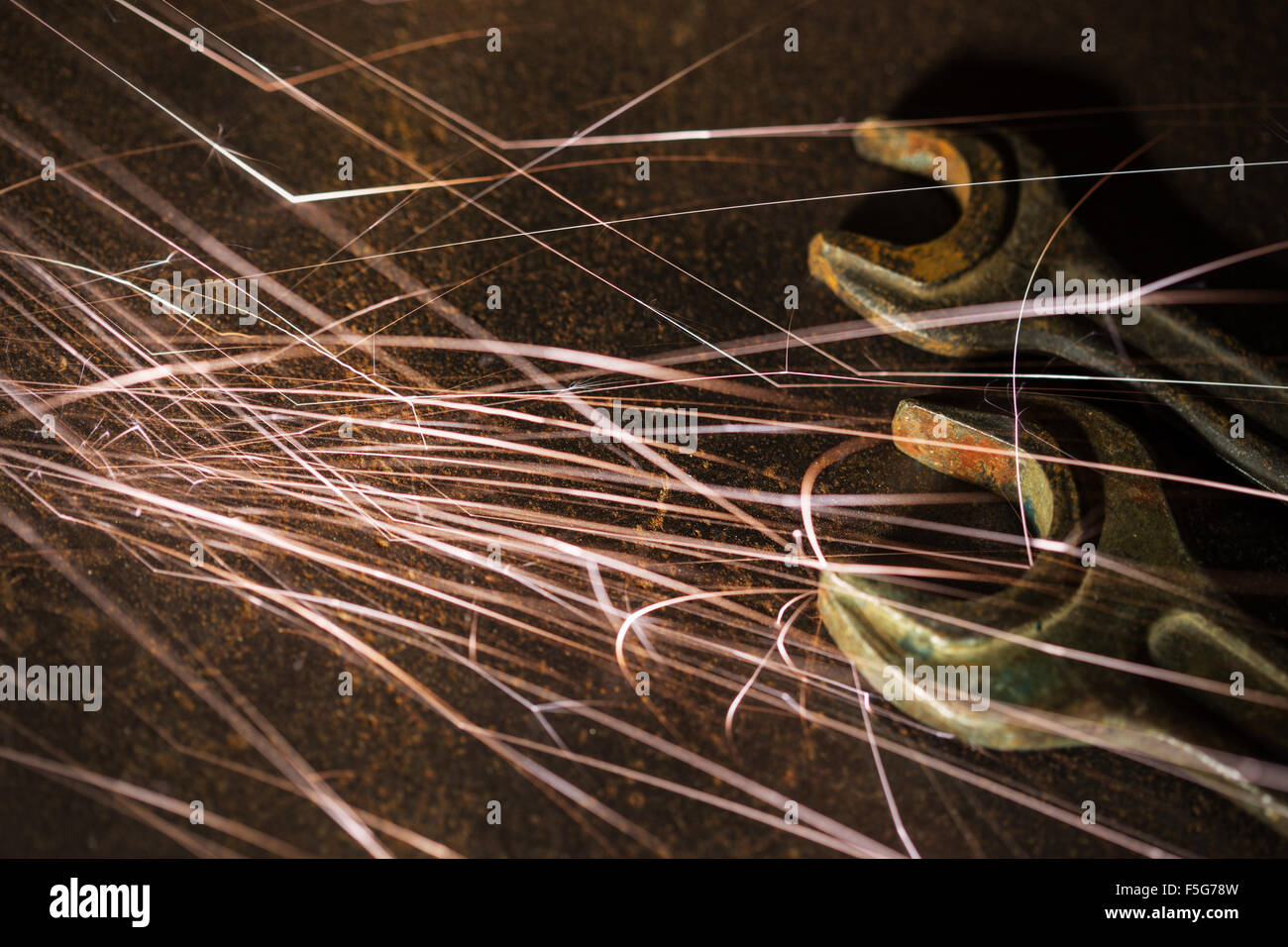 Flowing Sparks with old wrenches, industrial background Stock Photo