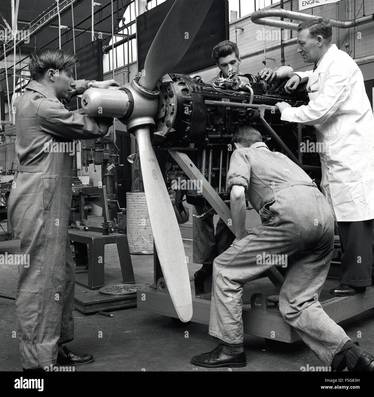 1950s, historical, In an aircraft hangar, aviation engineering or