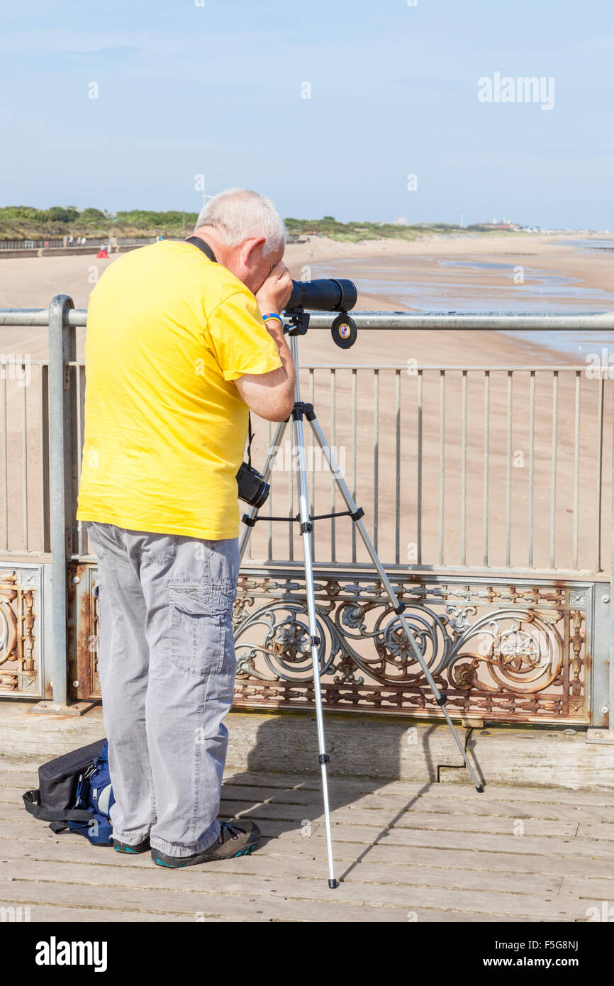 Person using a telescope or scope viewing the coastline from the pier at Skegness, Lincolnshire, England, UK Stock Photo