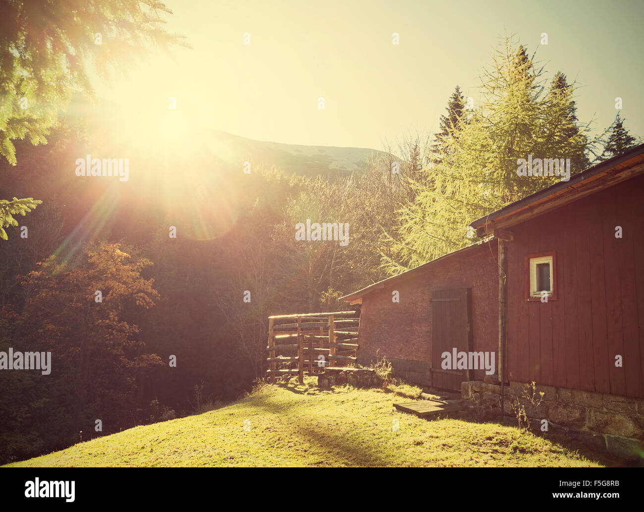 Retro vintage stylized mountain shelter against sun with flare effect. Stock Photo