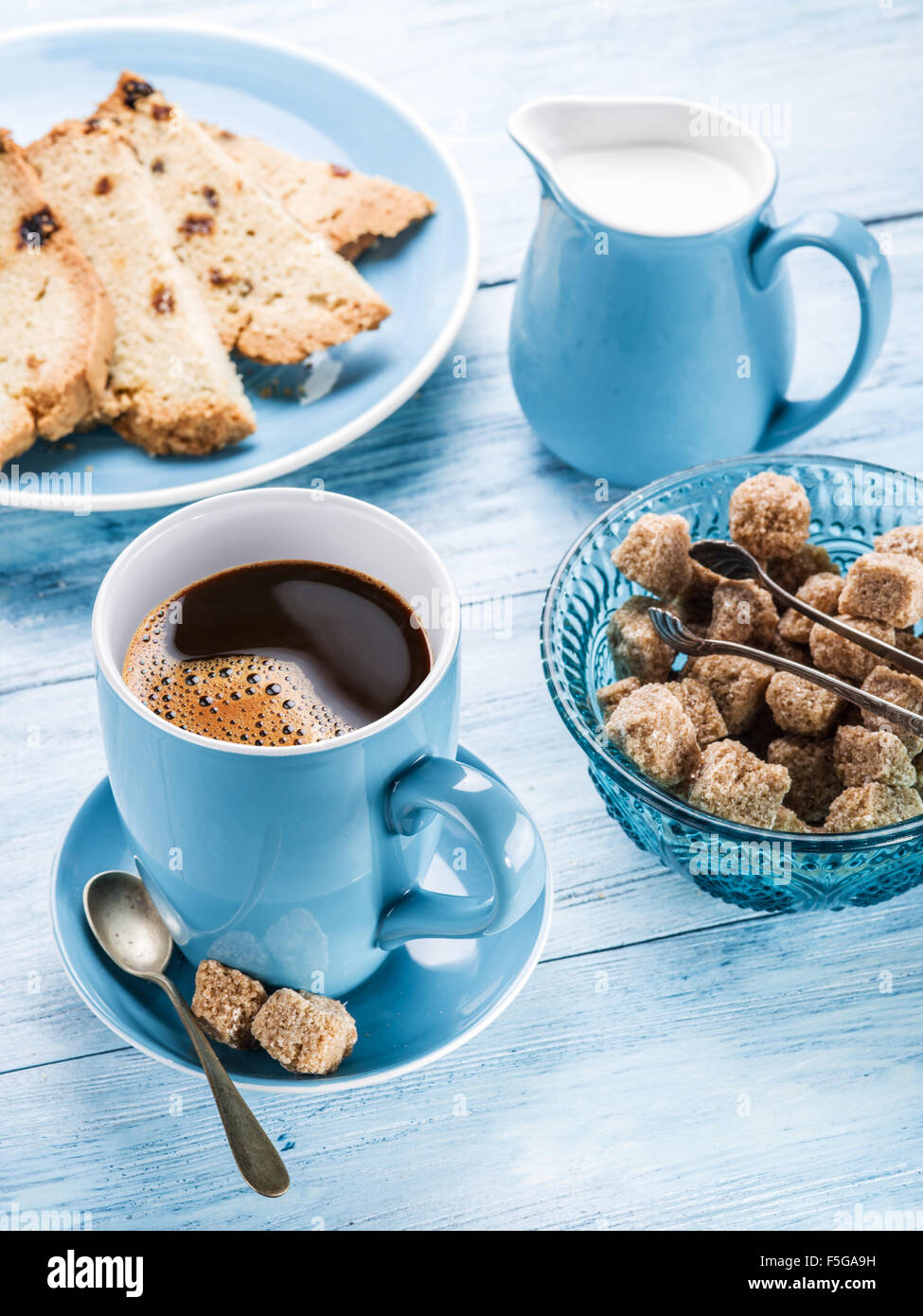 Cup Of Coffee Milk Jug Cane Sugar Cubes And Fruit Cake On Old