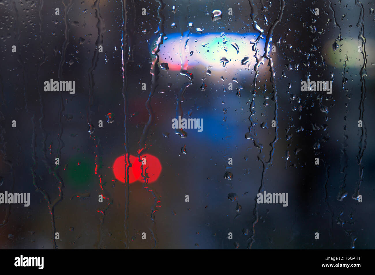 Rain drops on window - night light Stock Photo - Alamy