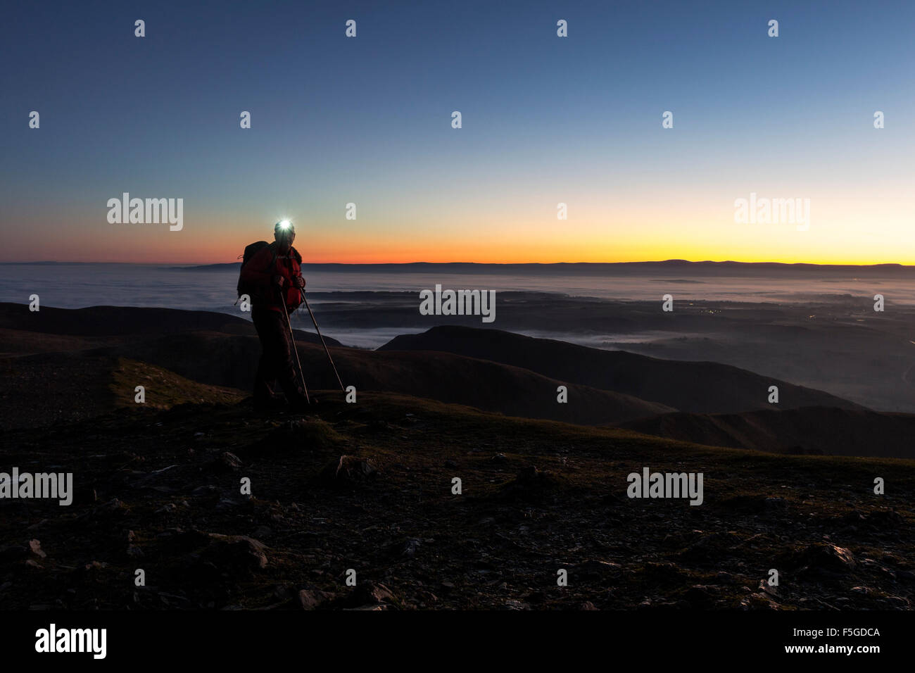 Hiker with Head Torch on the Summit of Blencathra in the Dark Lake District Cumbria UK Stock Photo