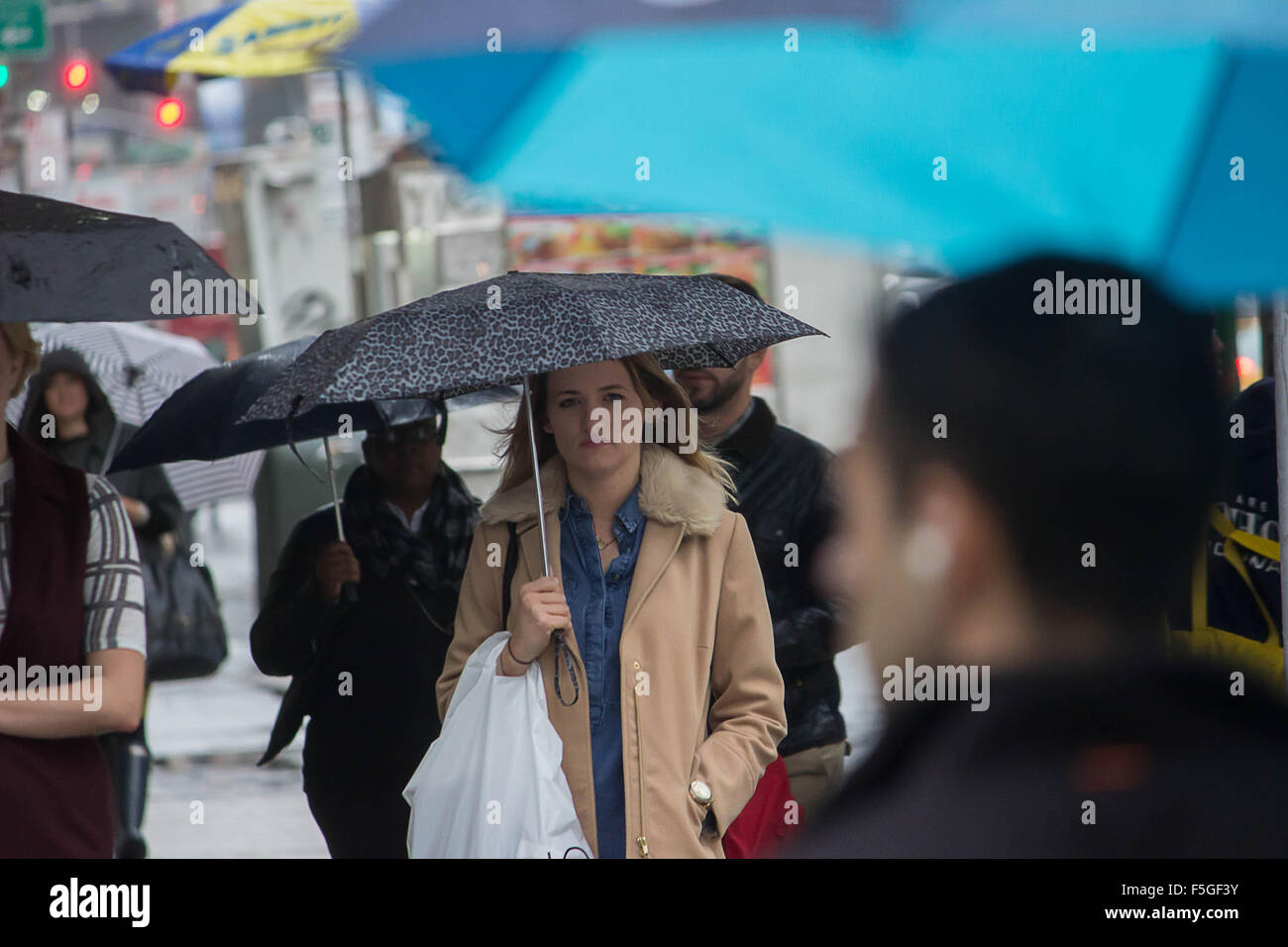 The Dreamer- a young lady is caught "guy-watching" before crossing the street on Broadway in New York City on a rainy day Stock Photo