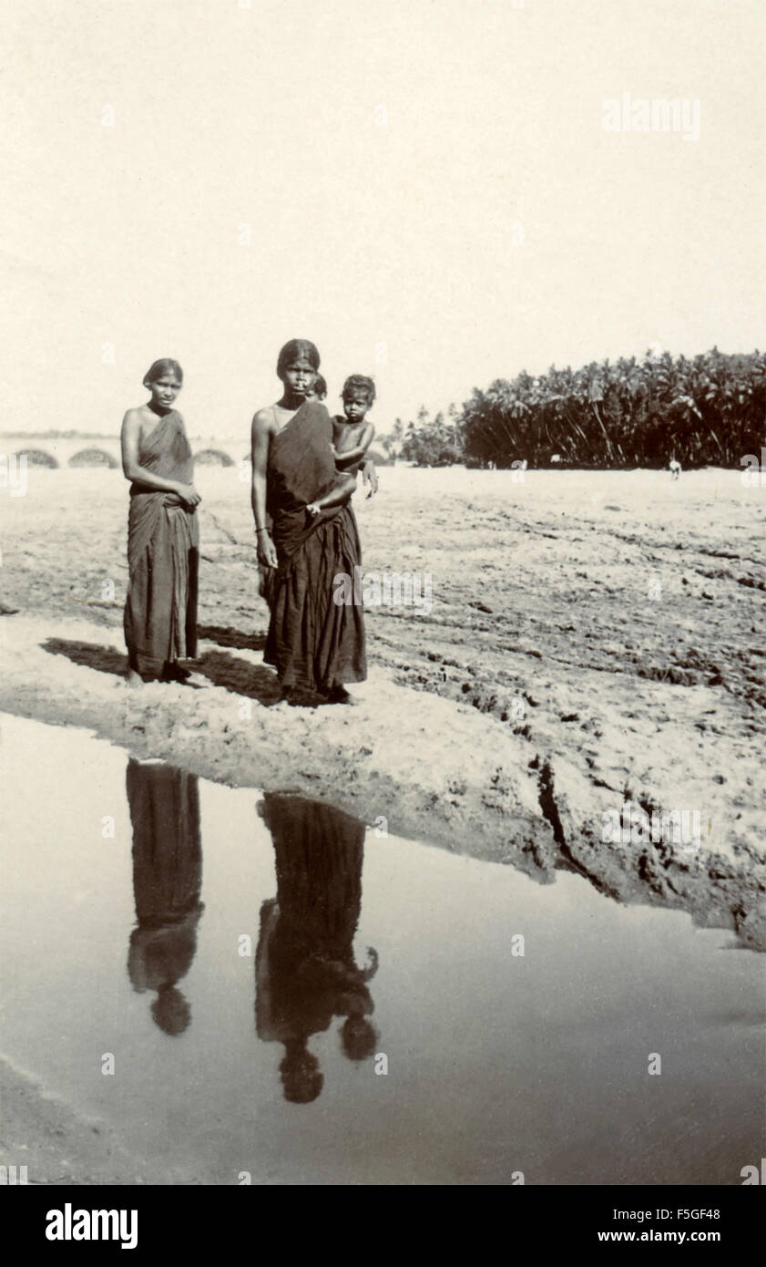 Women with children on the bank of a river, India Stock Photo