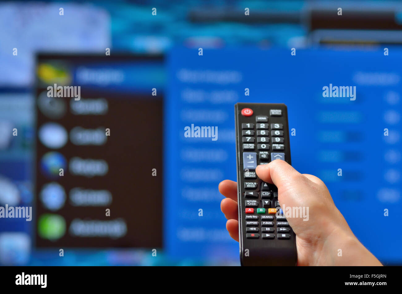 Smart tv and hand pressing remote control Stock Photo