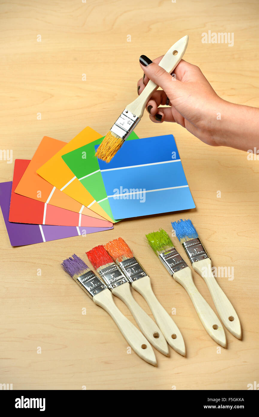 Paintbrushes and swatches with hand holding brush with yellow paint Stock Photo