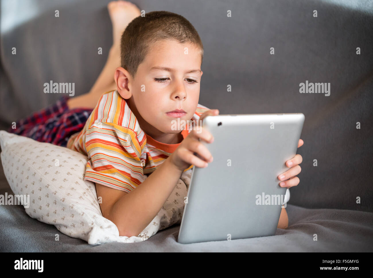Boy playing with digital tablet Stock Photo