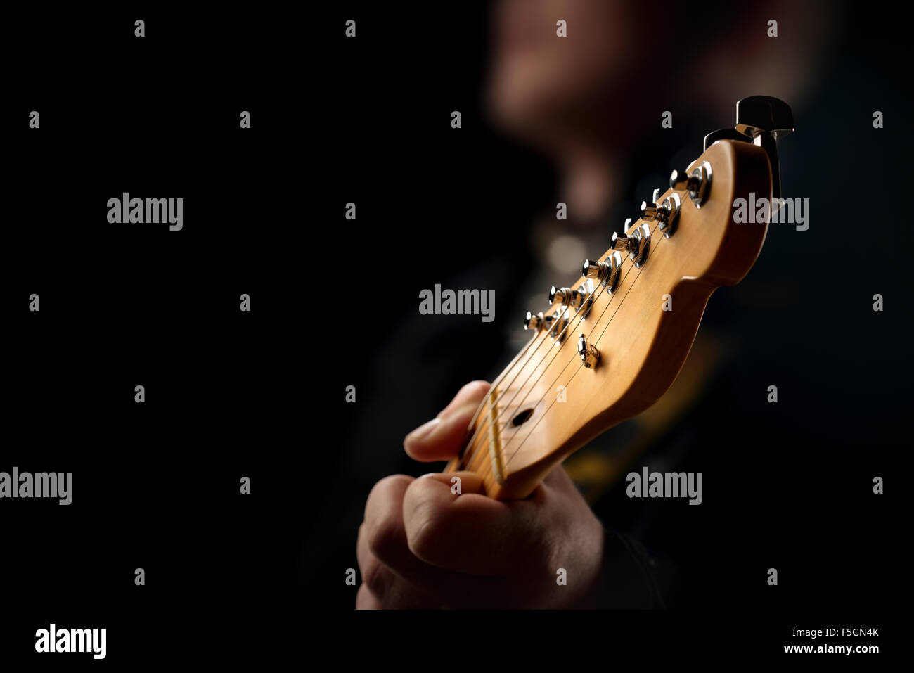 Guitarist on stage - closeup with selective focus on guitar head Stock Photo