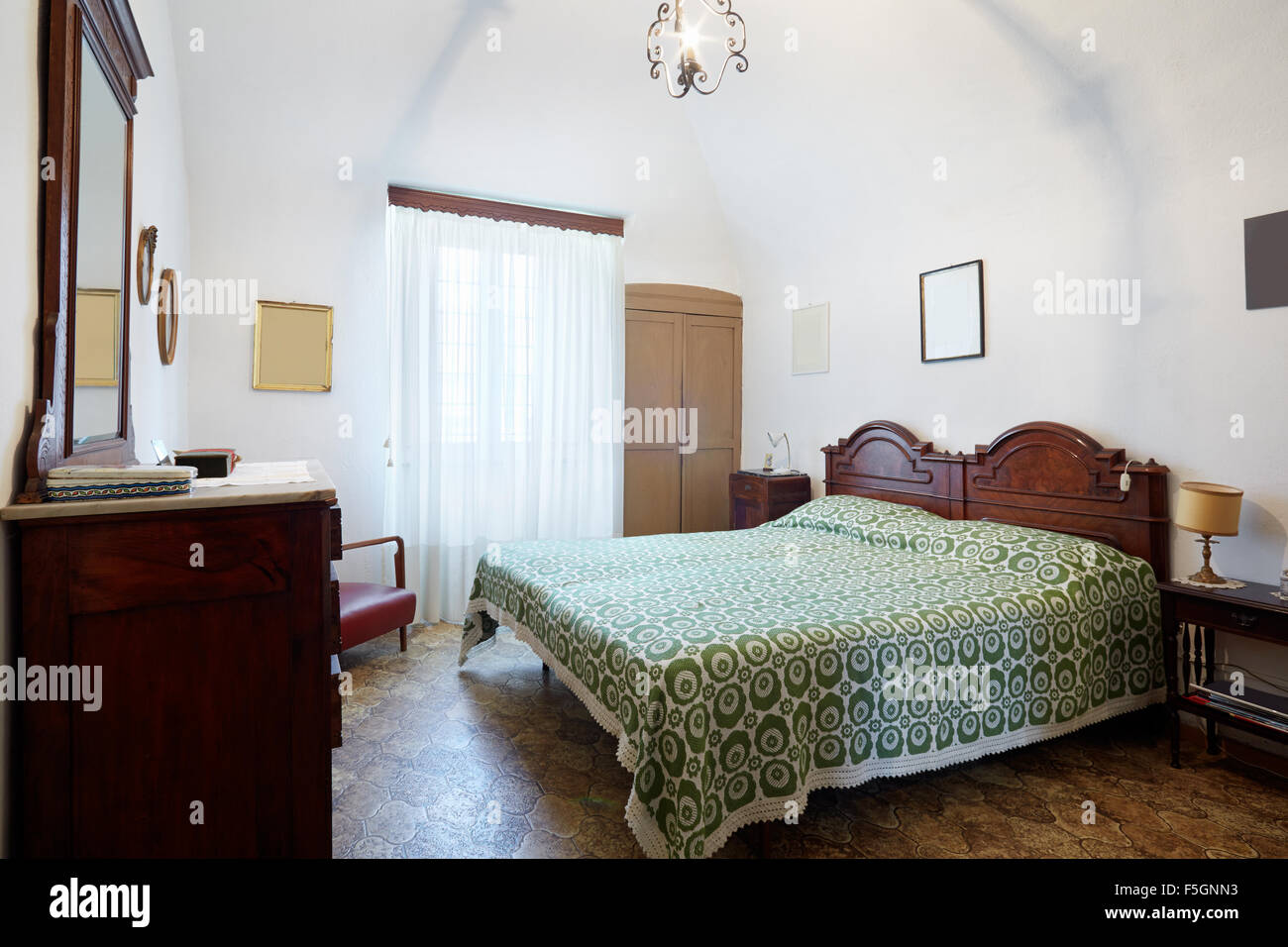Old bedroom with double bed in ancient Italian house Stock Photo