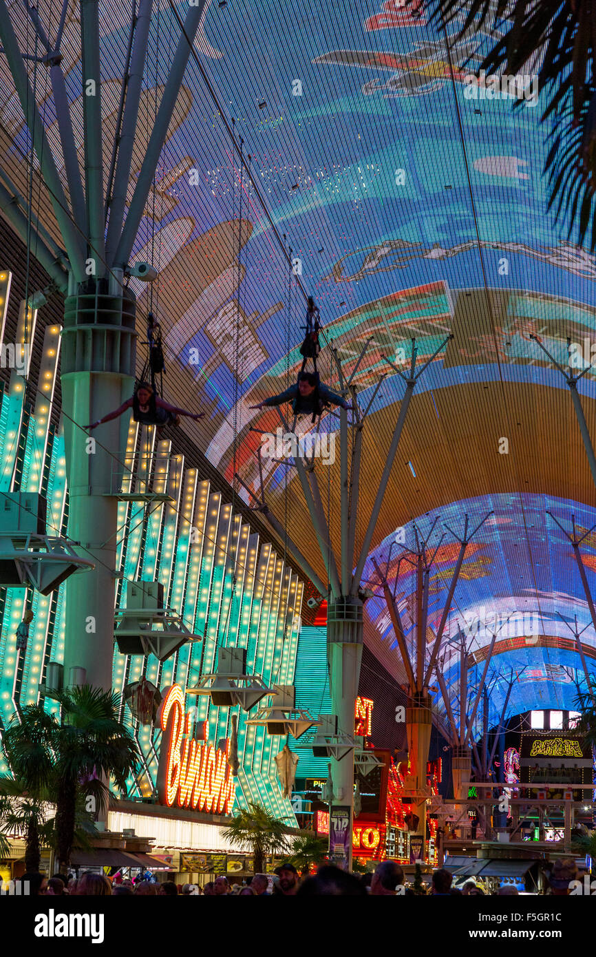 Las Vegas, Nevada.  Fremont Street.  Two Zip Line Riders on the Zoomline Passing Overhead during the Fremont Experience. Stock Photo