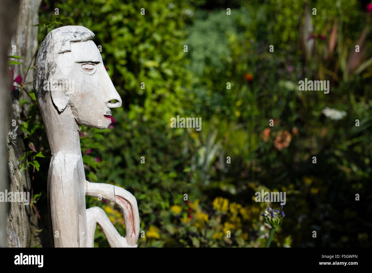 Male wooden figure in cottage garden Stock Photo