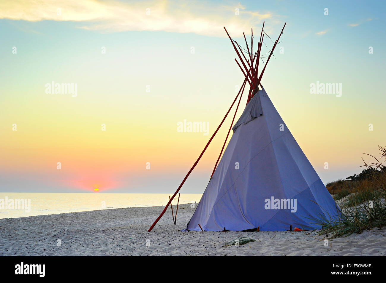 Traditional Teepee on a sea beach at beautiful sunset Stock Photo