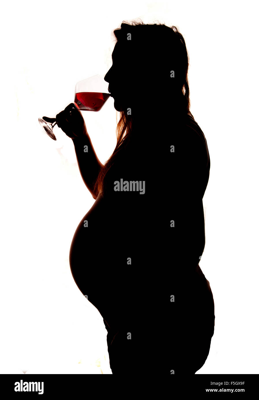 Pregnant women drinking red wine silhouette cutout Stock Photo