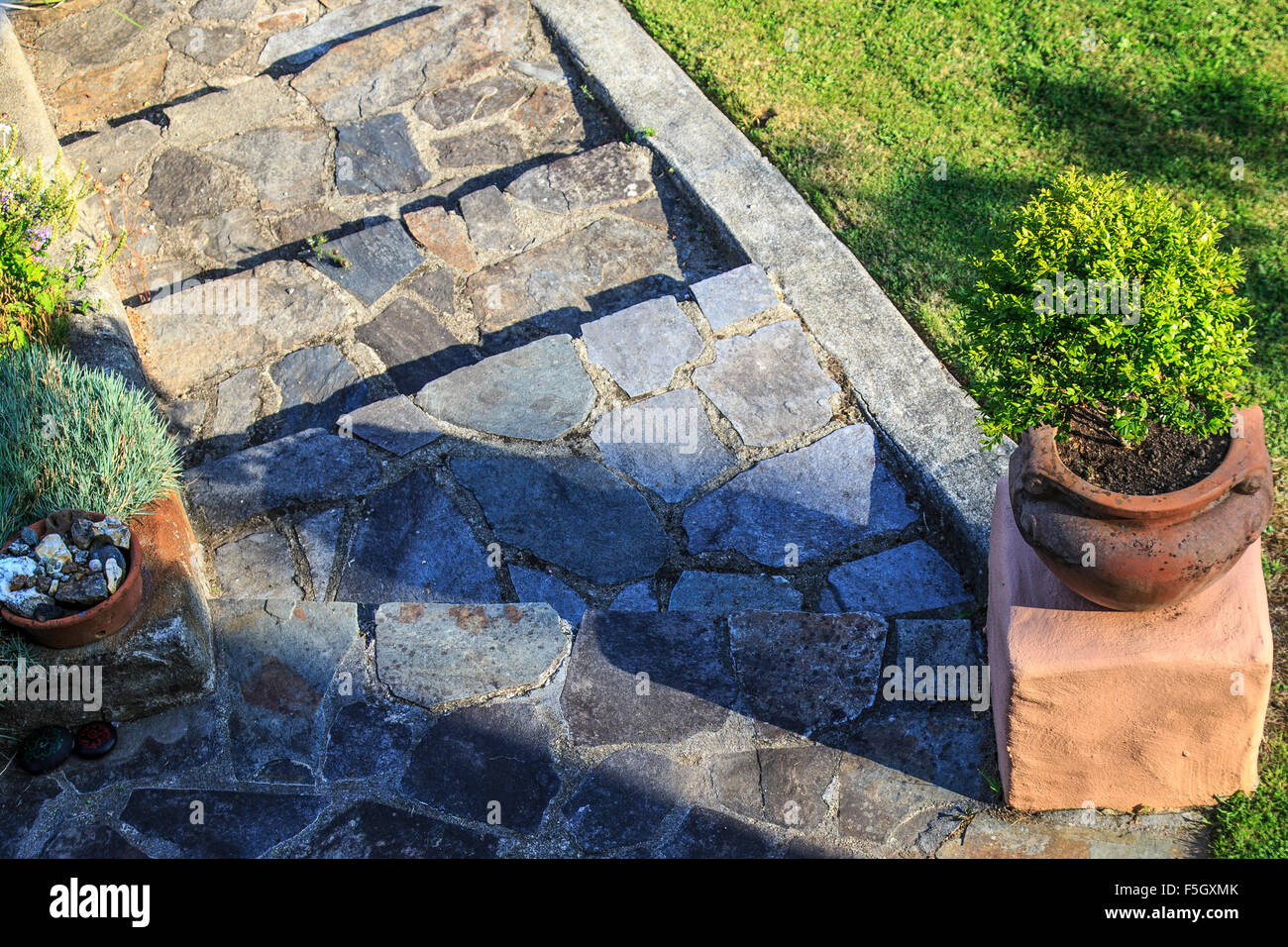 Stone path with plant pots. Crazy paving steps. Stock Photo