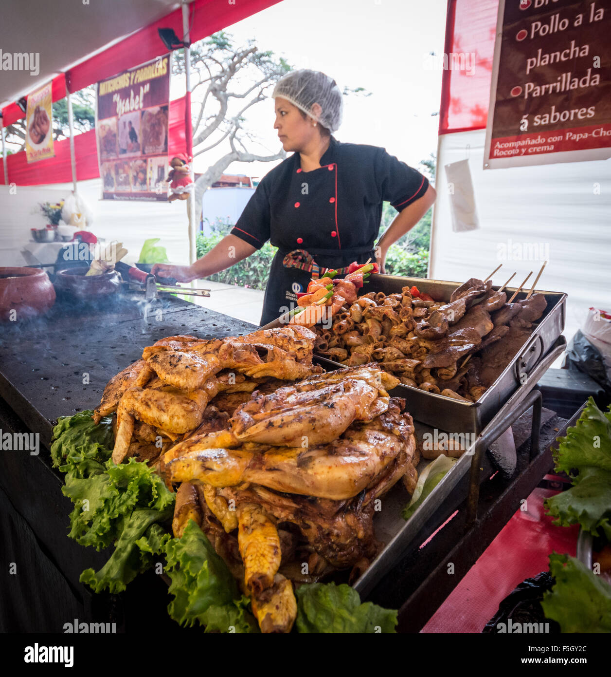 Street vendor sells grilled chicken and anticuchos (beef heart on skewer) at a food fair in Barranco district of Lima Peru Stock Photo