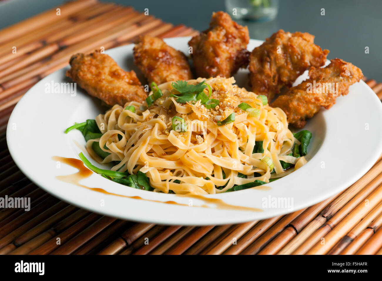 Chicken Wings with Noodles and Spinach Stock Photo