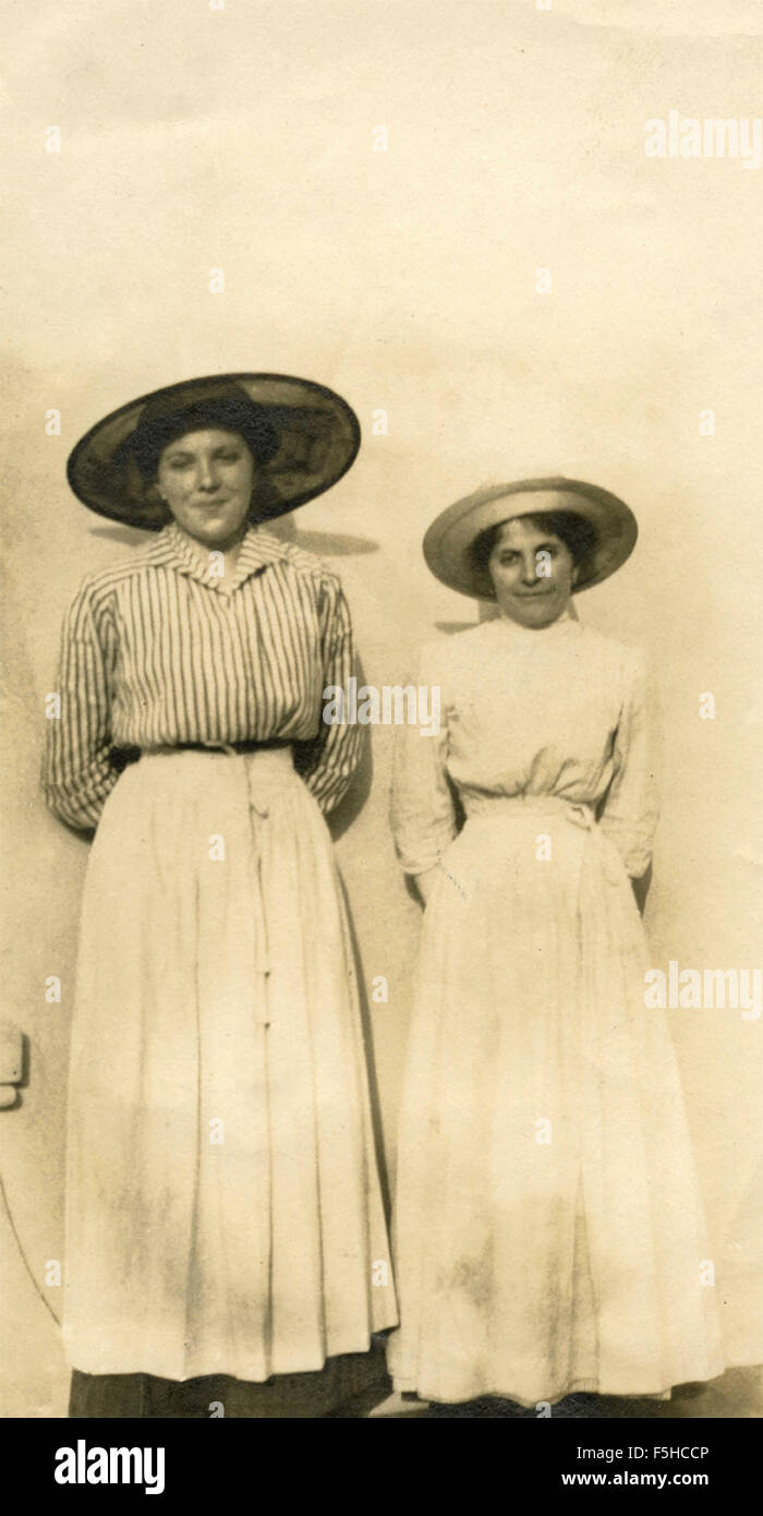 Two women with long skirts and wide-brimmed hats, Italy Stock Photo