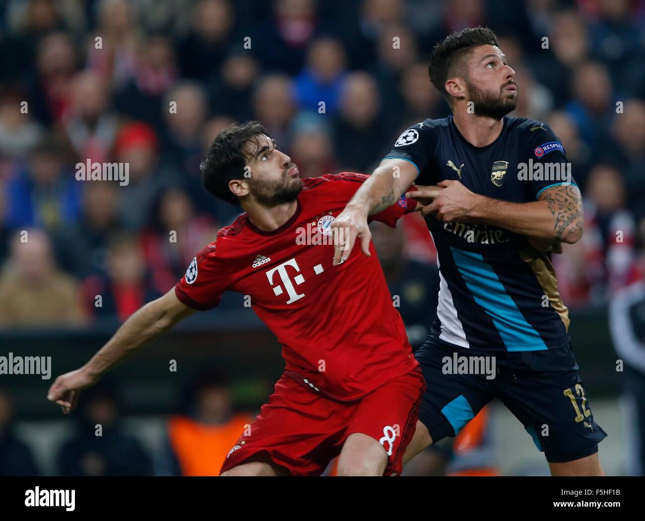 Munich, Germany. 4th November, 2015. Javi Martinez of Bayern Munich is challenged by Arsenal's Olivier Giroud during the UEFA Champions League Group F match between Bayern Munchen  and Arsenal at the Allianz Arena in Munich. November 4, 2015.  Credit:  James Boardman/Alamy Live News Stock Photo